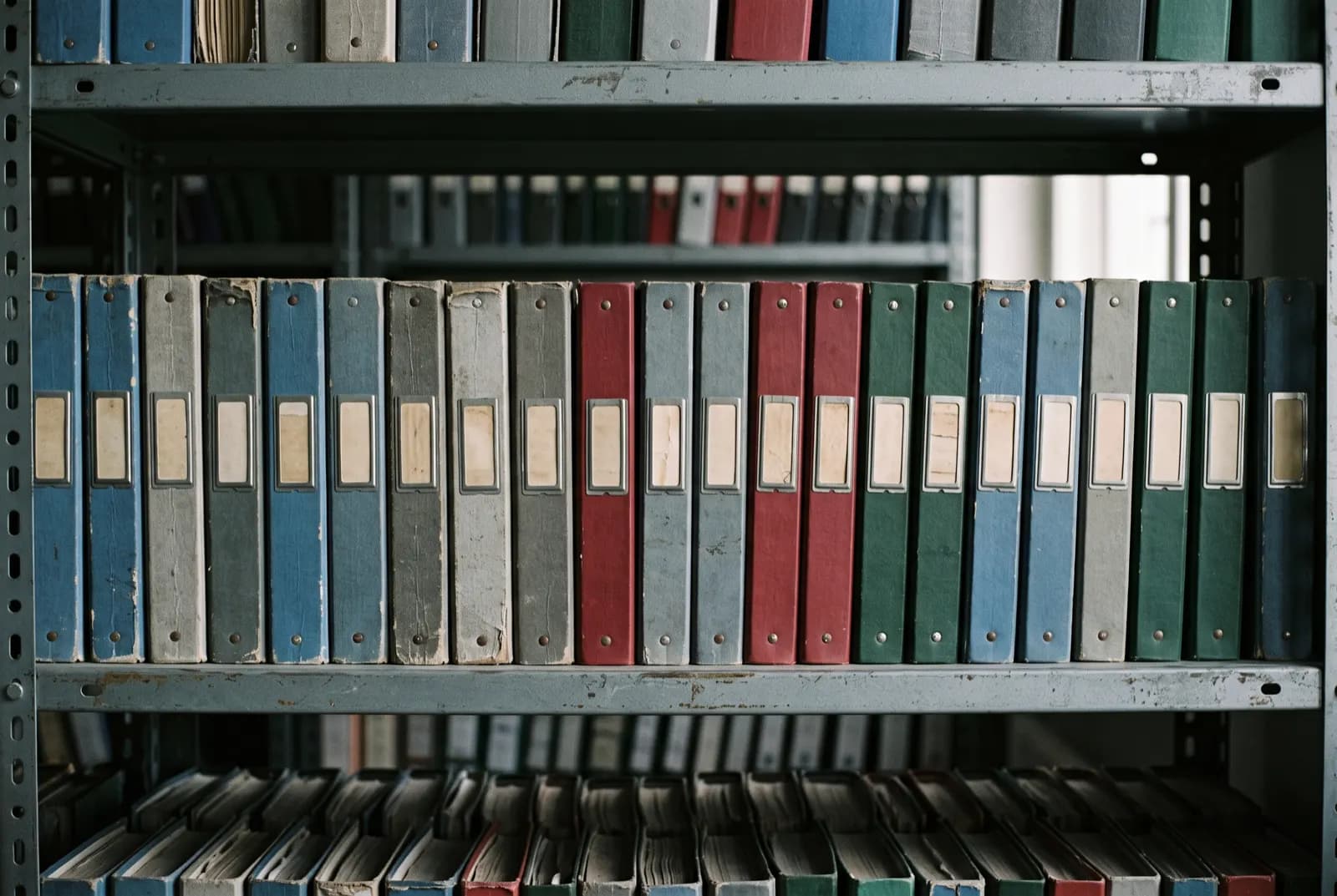 Carpetas de archivo alineadas en un estante de oficina